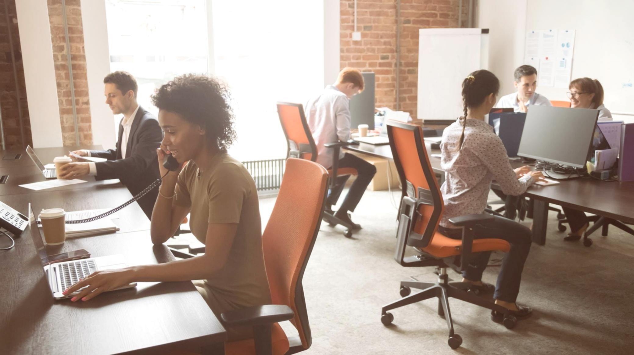 Equipo de profesionales trabajando juntos en análisis financiero durante sesión de formación empresarial